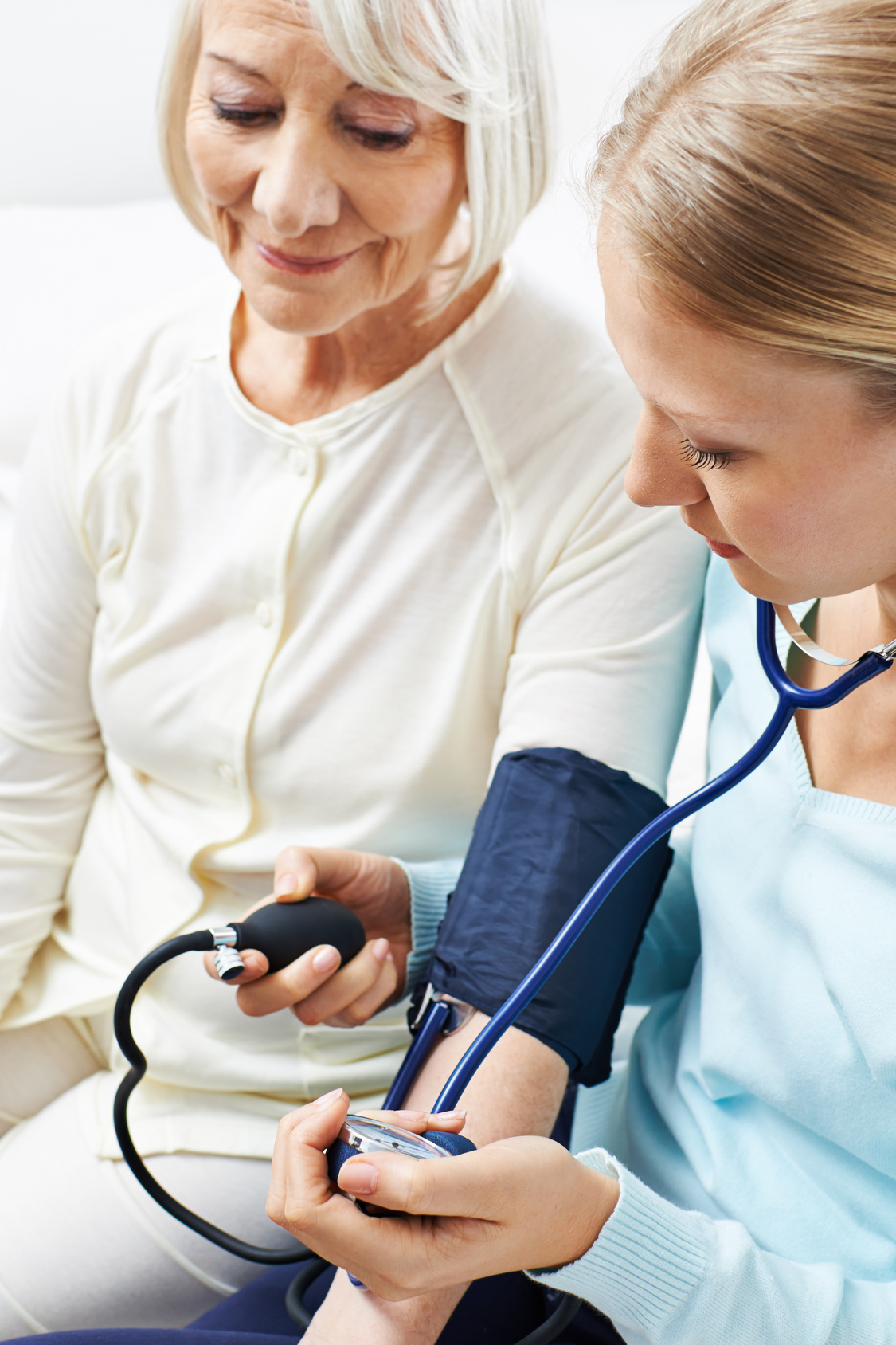 Frau beim Blutdruck messen von Seniorin