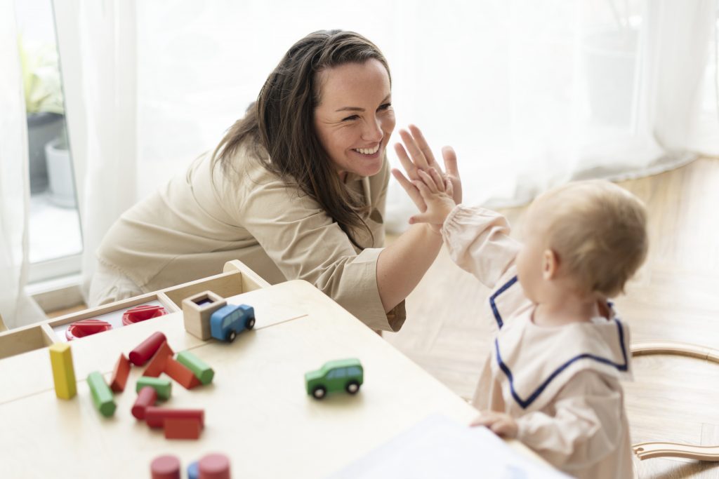 Mutter und Kind spielen mit Blauklötzchen